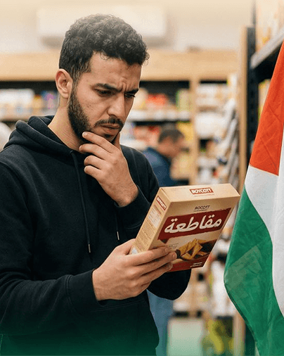 رجل داخل متجر يتفحّص المنتجات بعناية لاتخاذ قرار الشراء ضمن حملة المقاطعة
