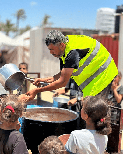 عامل إغاثة يقدّم الطعام للاجئين في غزة ضمن مبادرة إنسانية نظمتها مؤسسة سبيلي الخيرية